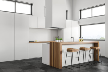 Corner of white kitchen with bar