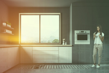 Gray kitchen with white counters, woman