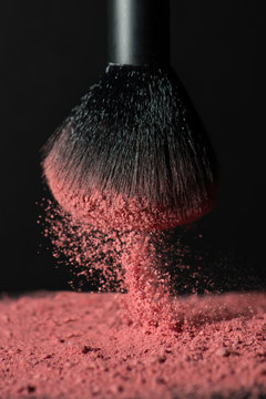 Close up of brush splashing pink face powder