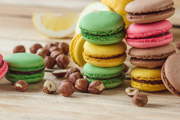 Green, pink, yellow and brown french macarons with lemon, kiwi and hazelnuts