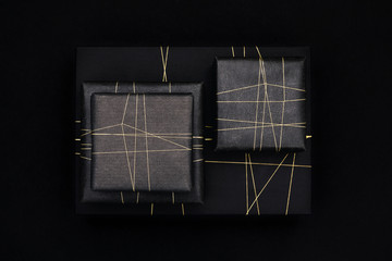 Gifts in modern black wrapping paper and a golden string