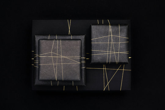 Gifts in modern black wrapping paper and a golden string