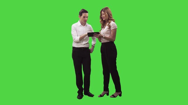 Businessman and a businesswoman working with a smartphone, fixing a problem in a  full body shot over a green screen.