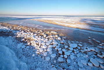 Frozen sea during sunset. Beautiful blue colored natural seascape in the winter time
