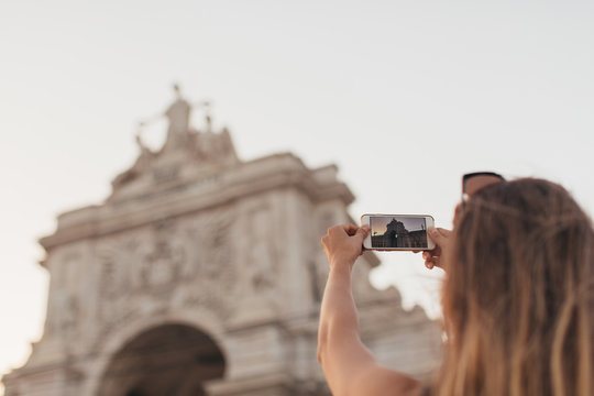 woman taking photos with smartphone at city