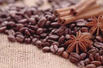 Aromatic roasted coffee beans and anis or badian, sticks of natural cinnamon on  background close up