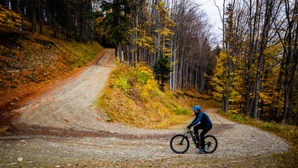 Mountain biker cycling in autumn mountains forest landscape. Man cycling MTB flow trail track....
