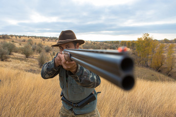 Hunter with a hat and a gun in search of prey in the steppe	