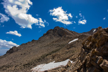 Landscape of snowy mountains and peak with blue sky and clouds.