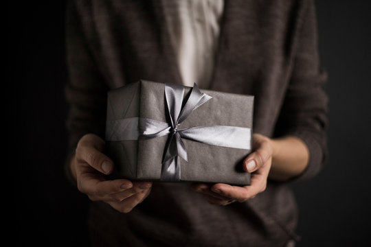 Person holding wrapped gifts and presents