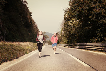 young couple jogging along a country road