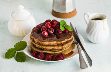 gluten-free green buckwheat pancakes with fresh berries and maple syrup. Delicious vegan breakfast without eggs, flour and  sugar. healthy food for the whole family. Moka pot with morning coffee