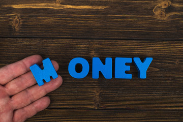 Hand and finger arrange text letters of MONEY word on wood table, with copy space for add advertising word or product. business and finance concept.