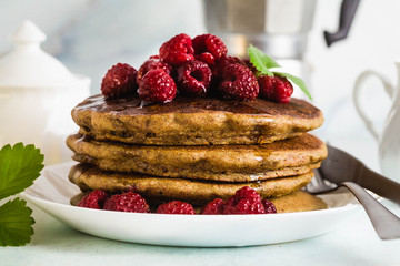 gluten-free green buckwheat pancakes with fresh berries and maple syrup. Delicious vegan breakfast without eggs, flour. healthy food for the whole family. Moka pot with morning coffee