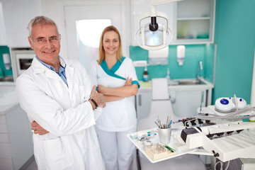 Portrait of dentist with female assistant in dental practice