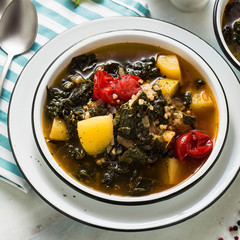 vegan winter kale soup with buckwheat , cherry tomatoes and potatoes. tasty full vegetable food for the whole family