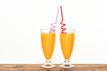 cups with mango juice on wooden countertop