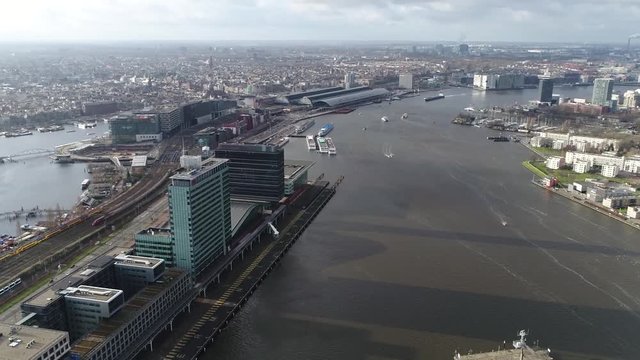 Aerial footage of Amsterdam city center panning left to Oosterdokseiland in english Eastern Dock Island which forms neighborhood just to the east of the central railway station 4k high resolution