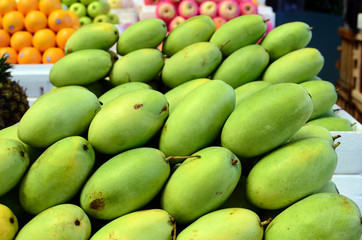 fresh green unripe mango fruits symmetrically to attrack buyers at market stall