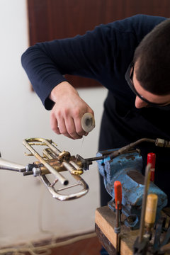 Man fixing trumps in his repair workshop
