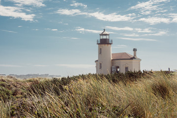 Fototapeta na wymiar Coquille River Lighthouse in Oregon, along the coastline of Bandon, OR. Seagrass in foreground