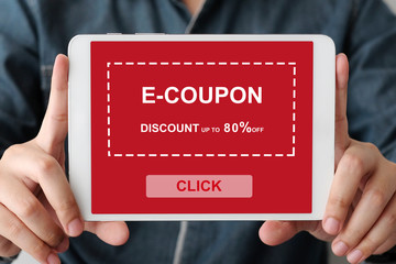 Hand holding digital tablet with discount coupon code on screen to get the shopping on line sale...