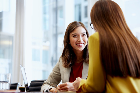 Smiling Businesswoman With Colleague At Table