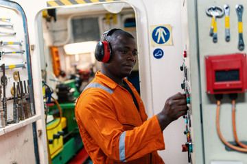 Marine engineer officer in engine control room ECR. Seamen's work. He starts or stops main engine of ship