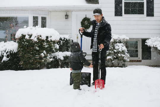 Dad and son with shovels in snow