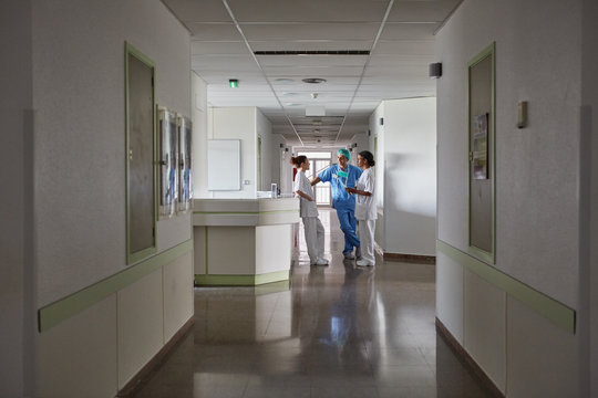Hospital hallway with group of staff and doctors talking