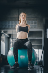 Fototapeta na wymiar Young attractive woman fitness doing exercises workout on ball in gym. Woman stretching the muscles and relaxing after exercise at fitness gym club.