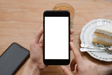close-up on hand holding phone showing white screen on desk at coffee shop.