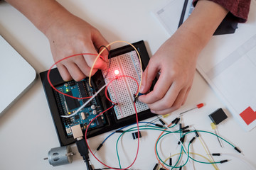 Boy working on an electronic DIY kit at home