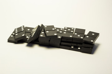 The knuckles of black dominoes are scattered over the white background