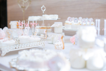The dessert table has cream cakes, cookies, pudding