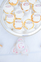 The dessert table has cream cakes, cookies, pudding