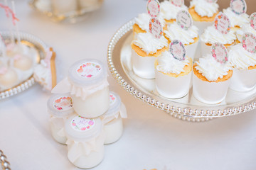 The dessert table has cream cakes, cookies, pudding