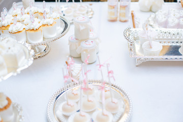 The dessert table has cream cakes, cookies, pudding