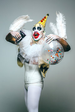Grotesque clown with confetti balloon