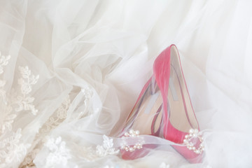 Fototapeta na wymiar Red heels and a white wedding dress