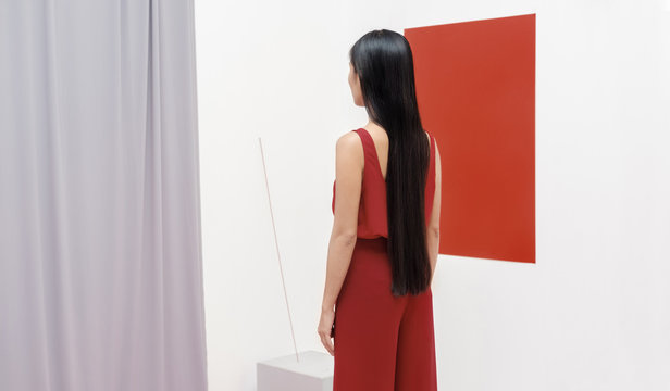 Asian fashionable female model with long hair in red in abstract space ./Fashion series