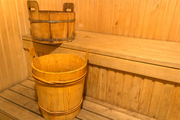 Naklejka premium wooden containers for cold water stand on a wooden shelf in a Russian bath
