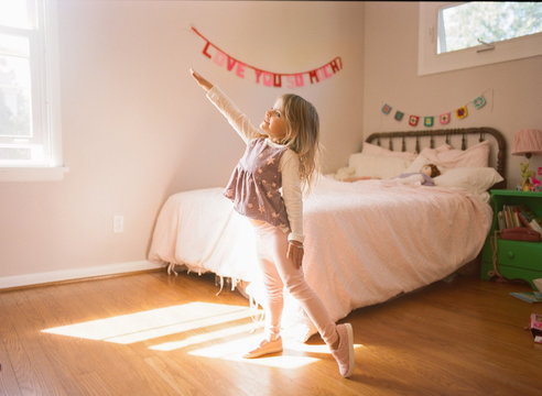 Little girl practicing ballet moves in her room