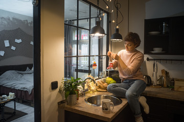 Young woman decorating kitchen for Christmas