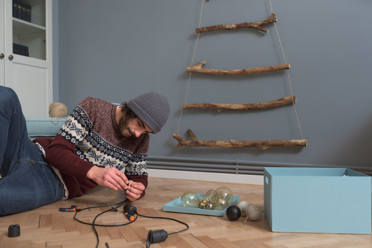 Man reparing the wire of electric Christmas lights