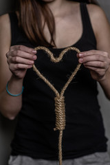 Teen girl holding the rope  in the form of a heart