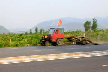 Fototapeta premium Small tractors are cleaning the health on the road, China...