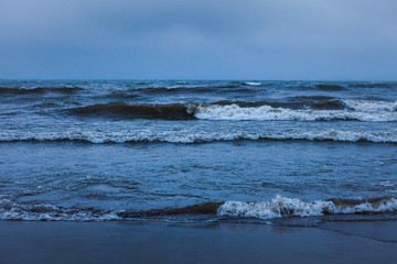 Fototapeta na wymiar Dramatic foaming splashing waves in stormy weather background