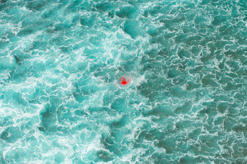 Spot of blood in a middle of ocean scape