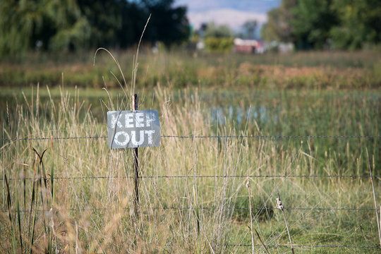 faded ""keep out"" sign on rural land